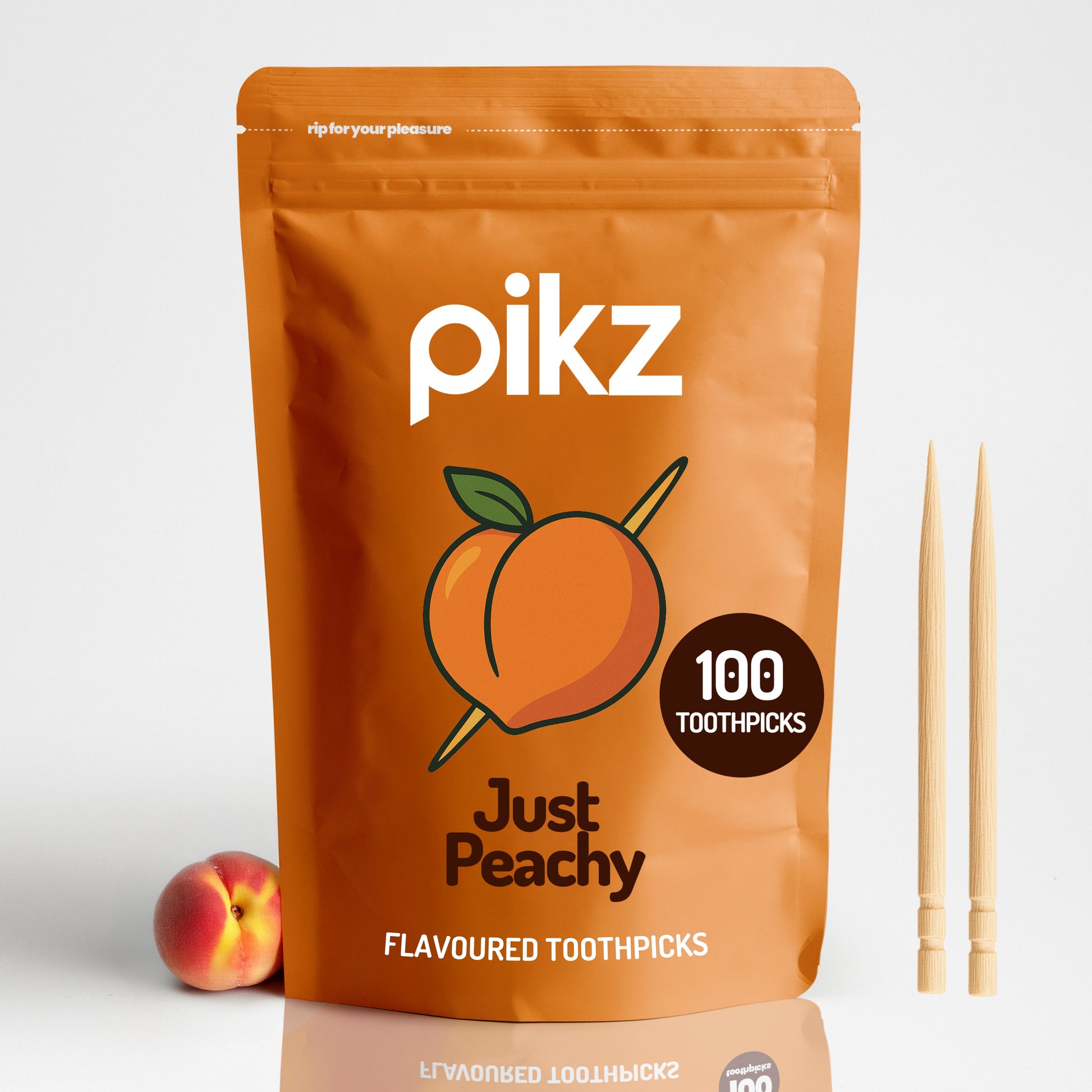 Pikz Just Peachy flavored toothpicks packaging with a peach and toothpicks on a white background